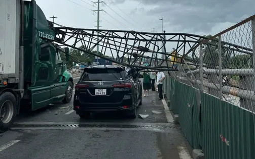 Cần cẩu bất ngờ đổ ập xuống đường, đè trúng xe container và ô tô 7 chỗ