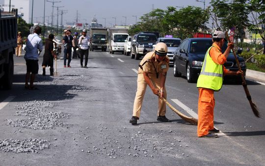 TP.HCM: CSGT quét dọn đá dăm đổ tràn ra đường