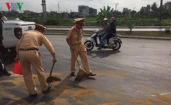 Cảnh sát giao thông xúc cát dọn vết dầu loang sau tai nạn