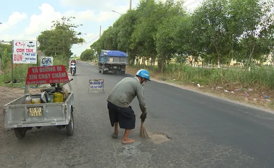 Người đàn ông bán vé số... vá đường