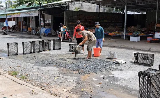 Tiền Giang: 2 nam thanh niên phơi nắng vá đường để tránh tai nạn