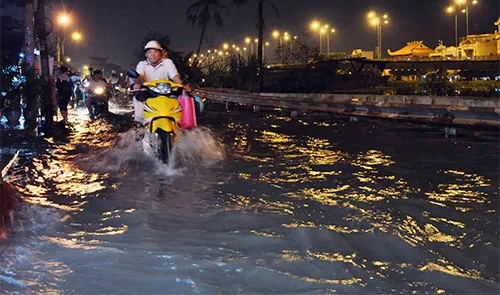 Người dân TP.HCM bì bõm đẩy xe trong dòng nước đen ngòm