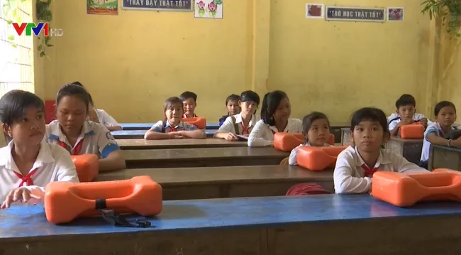 Students cross river to school during flood season